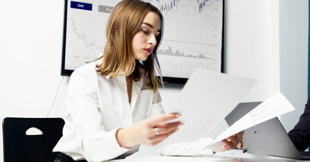 Uma mulher de cabelos longos e lisos revisando documentos em uma mesa de trabalho.